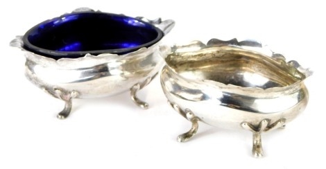 A pair of George V open silver salts, each of oval form with a fluted border, on tripod feet, Chester 1910, with one blue glass liner, 2.59oz.