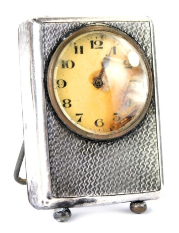 A George V silver cased mantel clock, with engine turned decoration, and a white enamel dial with metal hands, maker Spurrier & Co, stainless steel back, Birmingham 1927, 6.5cm high.