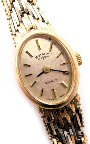 A Rotary lady's wristwatch, with an oval silvered dial, with baton markers and black hands, on abstract bi-colour bracelet, with safety chain, yellow metal, with rubbed marks, 18.6g all in.