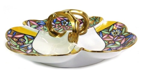 A Limoges porcelain hors d'ouevres dish, of three sectional form with shell capped border, with a gilded floral pattern and yellow borders, with a mounted central handle, 32cm diameter.