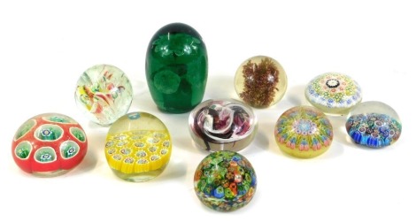 A collection of glass paperweights, comprising five millefiori cane weights, a green glass dump with floral decoration, and others, all unmarked. (a quantity)