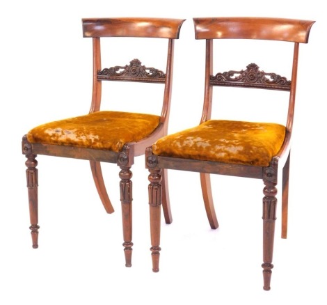 A pair of William IV rosewood dining chairs, with plain curved cresting rails and carved horizontal rails to the back, with drop in seats over slender turned and carved legs.