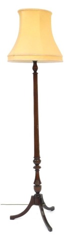 A 20thC mahogany standard lamp, with reeded column on tripod with splayed legs with a cream shade, 177cm high. WARNING! This lot contains untested or unsafe electrical items. It is supplied for scrap or re-conditioning only. TRADE ONLY