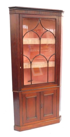 A 19thC mahogany standing corner display cabinet, the top with a fluted frieze, above an astragal glazed door, the base with two panelled doors, on a plinth, 209cm high, 97cm wide.