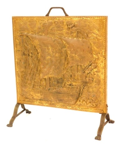 A 20thC brass fire screen, with embossed design of a gallon, on claw feet, 62cm high, 51cm wide, 22cm deep.