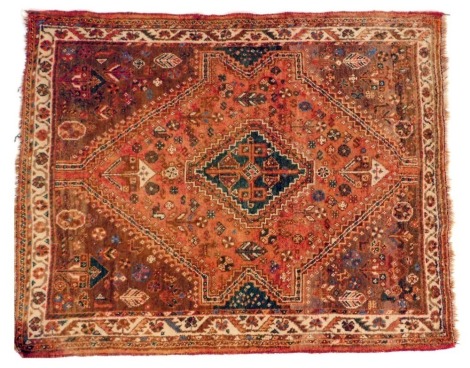 A Persian red ground rug, with central lozenge within multiple borders, 137cm x 168cm.