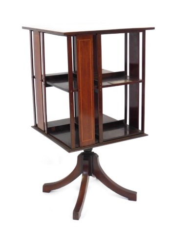 A George V mahogany revolving bookcase, with boxwood inlay and presentation plaque 'presented to Reverend E J Stevens by Parishioners of the Louth Parish Church as a Token of Esteem and Appreciation 1928-1929,' on four out splayed legs, 80cm high, the top