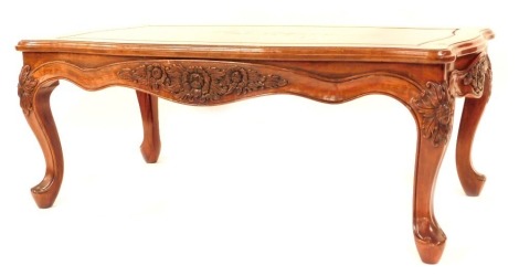 An Oriental hardwood coffee table, of rectangular form with shaped and fluted borders, with floral scroll out splayed legs, 49cm high, 116cm wide, 63cm deep.