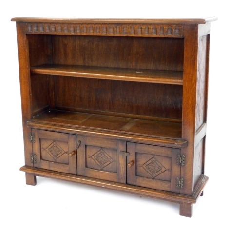 A reproduction oak open bookcase, with one adjustable shelf above arrangement of two cupboards, on stile feet, 92cm high, 102cm wide, 27cm deep.