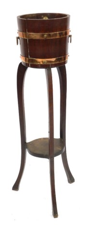 A George V oak palm tub, with copper banding and ring handles, on slender cabriole legs, bearing label for R A Lister & Co Dursley, 101cm high, 26cm diameter.