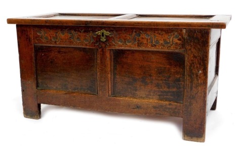 A late 17thC oak coffer, with a two panelled lid above a carved floral frieze, with panelled front and stile supports, 49cm high, 97cm wide, 43cm deep.