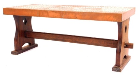 A hammered copper rectangular coffee table, with a shaped and bobbled top, on a trestle base, 45cm high, 109cm wide, 47cm deep.