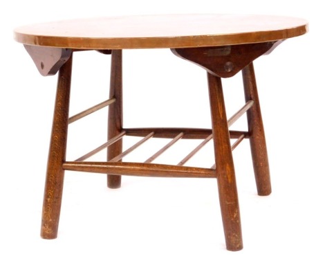 An Arts and Crafts influenced copper topped coffee table, the circular top above Ercol base, with under rack, 40cm high, 60cm diameter.