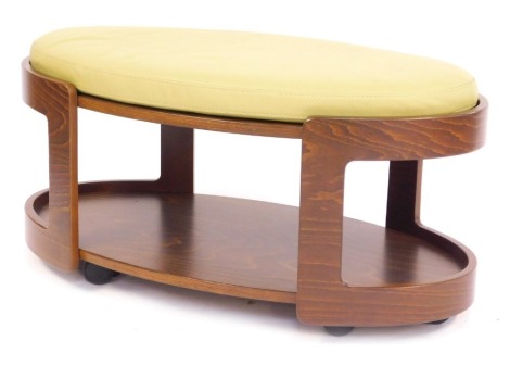 An Ekorness Stressless oval ottoman coffee table or footstool, with removable green leather cushion, on castors.