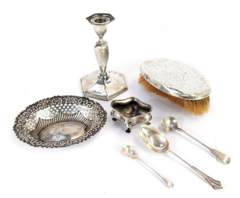 A group of silver, comprising a salt, hallmarks worn, a Victorian oval sweet meat basket, with pierced and embossed decoration, Birmingham 1899, Georgian silver salt spoon, silver mustard spoon and teaspoon, 3.55oz, together with a loaded silver candlesti