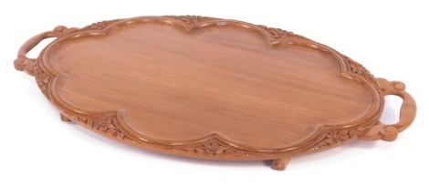 An early 20thC Anglo Indian twin handled hardwood tray, of oval form, with foliate carving, 60cm wide.