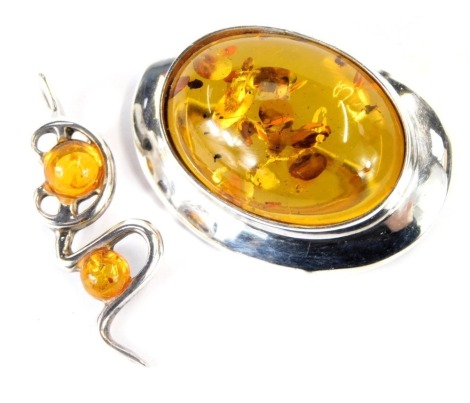 An amber set oval brooch, in white metal, stamped 925, and an amber set pendant, in white metal stamped 925. (2)