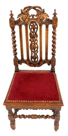 A late Victorian carved oak Carolean style chair, with fruiting vine cresting rail and splat, spiral turned supports to the back, and stretchers below to the turned legs.