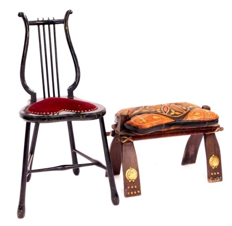 An early 20thC ebonised single chair, with lyre back and heart shaped padded seat, and a North African leather saddle seat. (2)