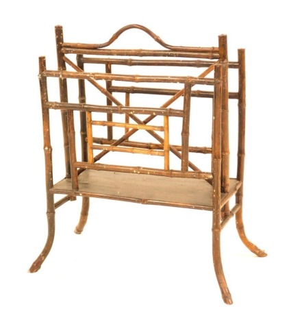 A Victorian bamboo magazine rack, with carrying handle and two divisions, on bent splayed legs.