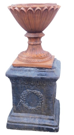 A terracotta planter or urn, of hourglass form, on a square base, 35cm high, together with a painted composition plinth, of square form decorated with laurel leaves, 41cm high.