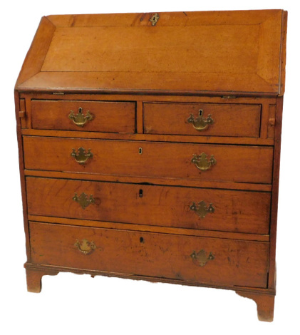 A George III oak bureau, the fall opening to reveal a central semi-secret drawer and two sliding column compartments, flanked by four recesses and eight drawers, above two short above three long drawers, raised on bracket feet, 116cm high, 103cm wide, 55c