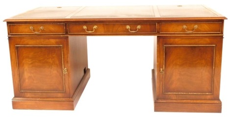 A reproduction Georgian style mahogany kneehole desk, with triple panelled green leather inset top and fitted three frieze drawers with cupboards below to the pedestals, 168cm x 86cm.