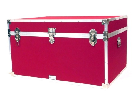 A large cabin type trunk by The Storage Trunk Company, with alloy metal framework and two carrying handles, in magenta cloth, 58cm high, 102cm wide, 74cm deep.