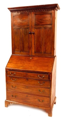 A George III mahogany bureau bookcase, with moulded dentil cornice and arcaded frieze to the upper cabinet enclosed by two panelled doors and fitted with three shelves, the bureau with fitted interior having pigeon holes and shallow drawers, etc., with fo