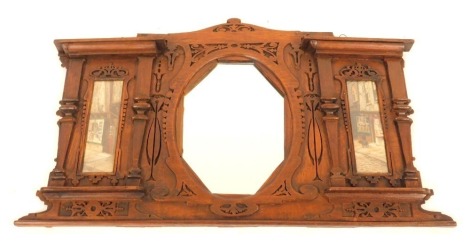 An Edwardian overmantel mirror, of architectural design with flat pilasters and fret cut decoration incorporating an octagonal central mirror flanked by two picture frame panels, incorporating watercolours of shop frontages, 94cm wide.