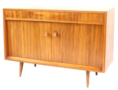 A 1960s Sapele sideboard by Everest, fitted with three frieze drawers and cupboard below enclosed by two doors with turned knop handles, decorated with lozenge shaped trading outlines of plain tapered legs, 92cm high, 138cm wide, 45cm deep.