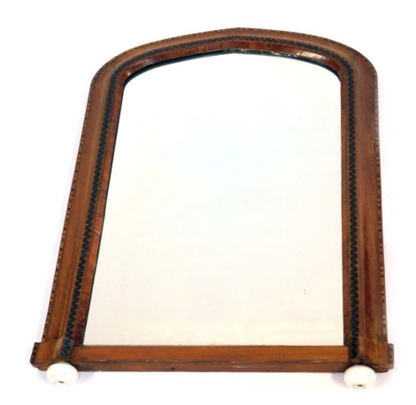 A Victorian walnut framed overmantel mirror, of slightly arched design decorated with Tunbridge inlaid borders and raised on white porcelain bun feet, 82cm high overall.