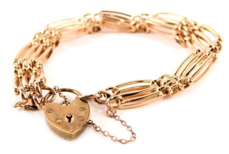 A 9ct rose gold gate bracelet, of four bar design with heart shaped padlock and safety chain, 18.5g, 18cm long.