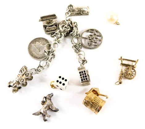 A charm bracelet, of fancy link design, with white metal mounts stamped 925, with seven white metal charms, some stamped silver, and a group of loose charms, to include yellow and white metal unmarked, cat in dumpster, spinning wheel, dog, dice and cultur