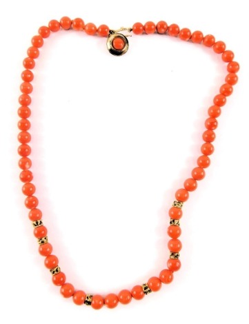 A coral type necklace, with spherical beads and gold marked breaks, with a white metal clasp stamped 925, 42cm long overall.