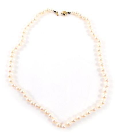 A single strand cultured pearl necklace, with pink lustre finish beads on a knotted string strand, with a yellow metal circular clasp on plain design, stamped 375, 44cm long, 14.2g all in.