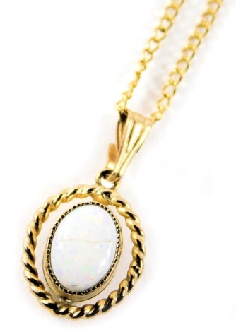 A 9ct gold opal pendant and chain, the oval opal with rope twist border, 1.5cm wide, on a fine link neck chain, 44cm long, 1.8g all in.