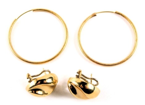 Two pairs of earrings, comprising a pair of yellow metal hoop earrings, 3.5cm diameter, yellow metal unmarked, and a pair of modern twist design clip on earrings, stamped 9kt, 2cm high, 6.2g all in. (2)