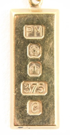 A 9ct gold ingot pendant and chain, the rectangular ingot, maker PM, Sheffield 1984, 3.5cm high, on a curb link neck chain, 52cm long, 17.4g.