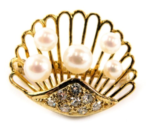 An oyster shell brooch, of pierced design set with five cultured pearls, and set with tiny diamonds to base, yellow metal stamped 9kt, on single pin back, 2cm wide, 3.6g all in.