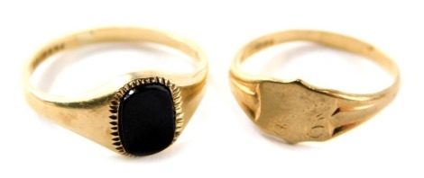 Two 9ct gold dress rings, comprising a signet ring with floral design shield, ring size H½, and a black onyx set signer ring, ring size L½, 2.6g all in. (2)