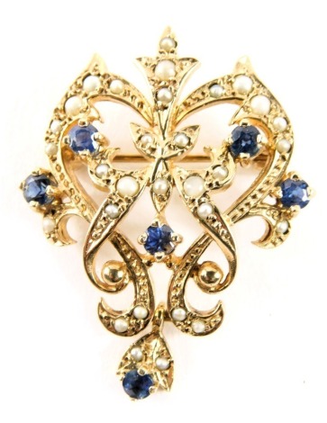 A 9ct gold Art Nouveau pendant/brooch, set with seed pearls and sapphires, of scroll design with pendant mount and single pin back, 3.5cm high, 3cm wide, 6.7g all in.