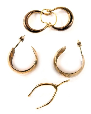 A group of loose hoop earrings, yellow metal unmarked, and a 9ct gold wishbone pendant, 5.8g all in.