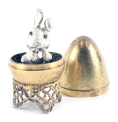 A Stuart Devlin silver parcel gilt Mad March Hare egg, the brushed egg opening to reveal a silvered hare, numbered 159 to underside, London 1973, with unmarked silver gilt coloured stand, 6.40oz, 7cm high, boxed with certificate, limited edition number 20