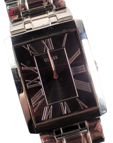 A Guess gent's stainless steel wristwatch, with a blackened Roman numeric dial, 2.5cm x 3.5cm, on stainless steel strap.