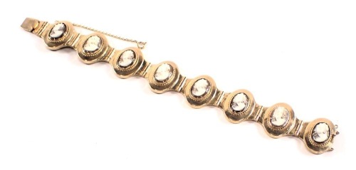 A cameo bracelet, with eight oval panels, each with raised cameo depicting female figure, in a rubbed yellow metal bracelet frame, with safety chain and clasp, stamped 375, 20cm long, 37.8g all in, boxed.