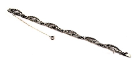 A marcasite bracelet, each link of oval shaped form set with marcasite, with clip and safety chain, white metal unmarked, 19cm long, 17.5g all in.