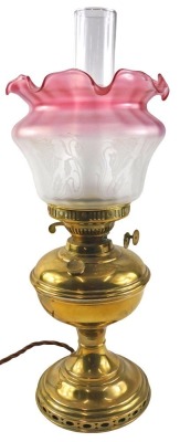 A brass oil lamp, the pink and white frosted shade decorated with flowers in Art Nouveau style, 50cm high. WARNING! This lot contains untested or unsafe electrical items. It is supplied for scrap or re-conditioning only. TRADE ONLY