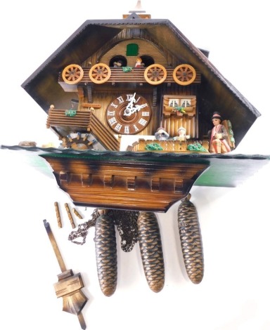 A large Black Forest cuckoo clock, modelled in the form of a Swiss chalet, with moving figures, etc., 43cm wide.