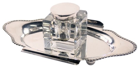 A silver plated inkstand, with a fluted and reeded tray, with two pen slips, and central square inkwell stamped EPNS, the tray unmarked, 7cm high, 14cm wide.